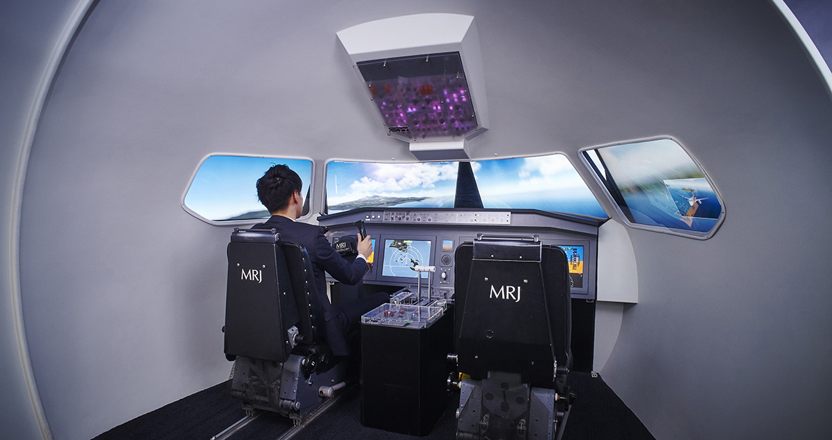 A mock-up of the cockpit of the Mitsubishi Regional Jet (MRJ) features a simulator with responsive controls and wrap-around of computer generated images to create a realistic sensation of piloting the aircraft.