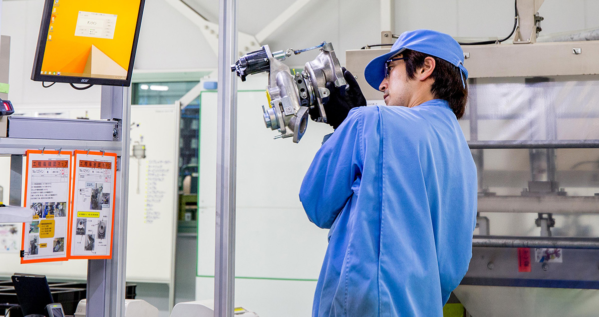 An expert technician checks a turbocharger fresh off the production line.