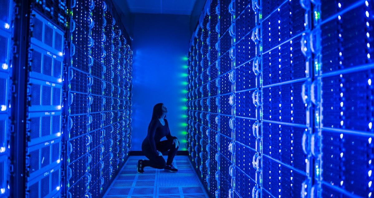 Side-view-of-woman-working-in-illuminated-server-room.jpeg